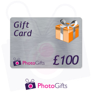 Grey £100 gift card with the writing Gift Card and Photogifts Logo as well as a picture of a gold wrapped box