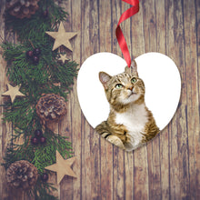 Load image into Gallery viewer, Dark wooden background with a Christmas Garland stretched out on the Left hand side from top to bottom. On the garland are some wooden stars and fir cones along with some dark red berries. To the right of the garland is a Christmas Decoration in the shape of a heart with a red ribbon. The decoration is is a picture of a tabby cat with a white background. Decoration as supplied by Photogifts.co.uk