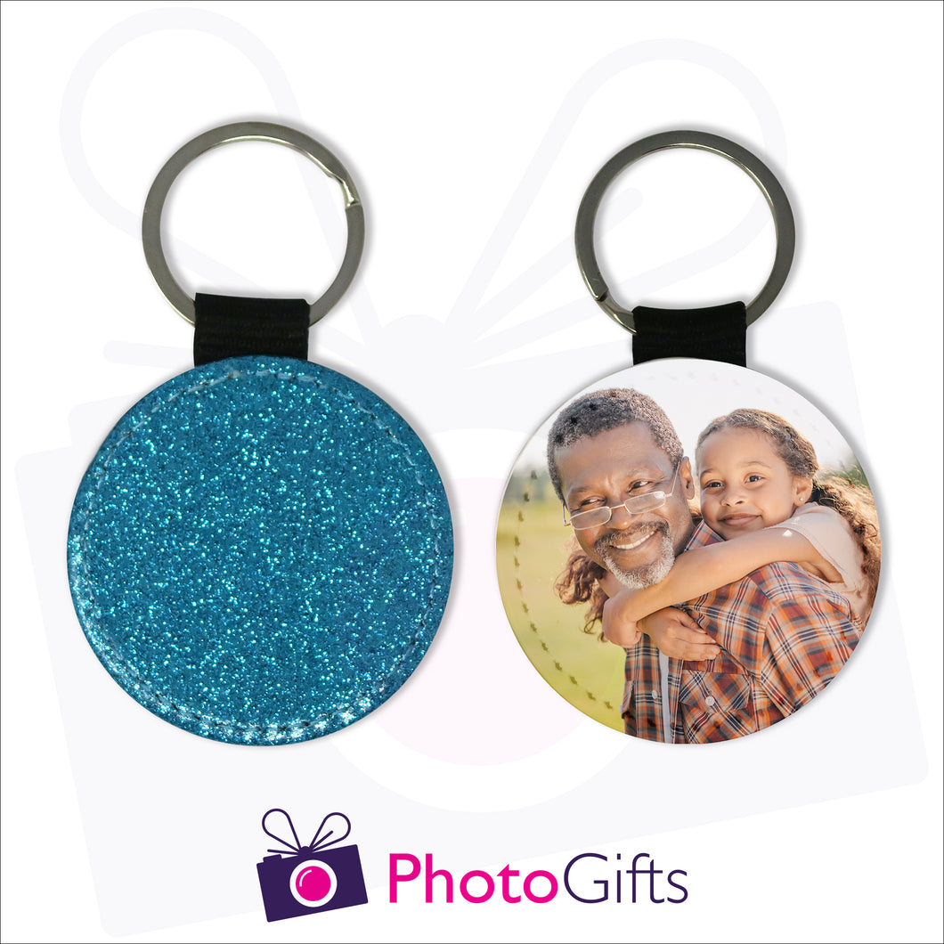 Two sides of a round keyring. On one side is a blue glitter covering the whole keyring and on the other side is a picture of a grandfather giving his granddaughter a piggy back in a field. Keyring as produced by Photogifts.co.uk