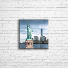 Load image into Gallery viewer, Personalised 12x12&quot; square wrapped canvas with your own choice of image hung on a white brick wall by Photogifts.co.uk
