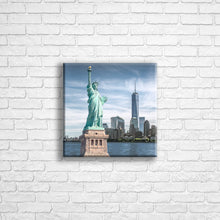 Load image into Gallery viewer, Personalised 12x12" square wrapped canvas with your own choice of image hung on a white brick wall by Photogifts.co.uk
