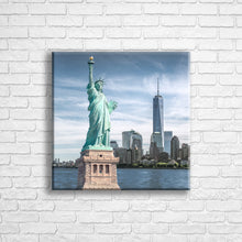 Load image into Gallery viewer, Personalised 16x16" square wrapped canvas with your own choice of image hung on a white brick wall by Photogifts.co.uk