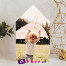 Load image into Gallery viewer, White wooden block in the outline of a house with a personalised photo of a boy and his kite attached to the block on a white shelf with a plant and a candle holder on either side. Block and personalised photo as supplied by Photogifts.co.uk