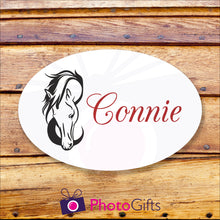 Load image into Gallery viewer, Oval metal outdoor sign on a wooden background. Within the oval panel is a picture of a horses head and to the right is the word "Connie" in red text. All as produced by Photogifts.co.uk