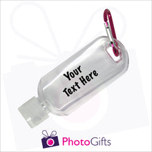 Load image into Gallery viewer, Close up image of a small 50ml clear plastic travel bottle together with a pink carabiner. Bottle is personalised with &quot;Your text here&quot; in black text. As supplied by Photogifts.co.uk 
