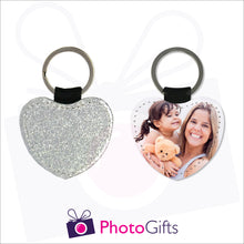 Load image into Gallery viewer, Front and back image of a heart shaped keyring. On one side the heart is all silver glitter and on the other is a photo of a mother holding a toddler and teddy bear in her arms. There is also the Photogifts Logo. Keyring as produced by Photogifts.co.uk
