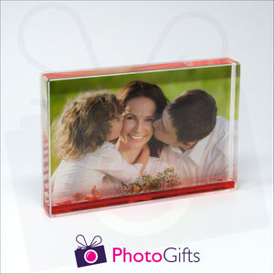 152mm x 102mm (6" x 4") clear acrylic freestanding block, in landscape orientation,  that can be personalised with your own choice of image. The block is filled with some red gel suspended within a clear liquid. The chosen image is clipped to the back of the block and shows through so you can see it behind the liquid. When the block is shaken the red gel will slowly make its way down to the bottom of the block similar to a snow globe