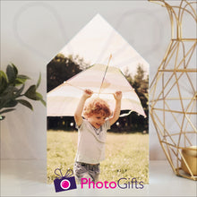 Load image into Gallery viewer, White wooden block in the outline of a house with a personalised photo of a boy and his kite attached to the block on a white shelf with a plant and a candle holder on either side. Block and personalised photo as supplied by Photogifts.co.uk
