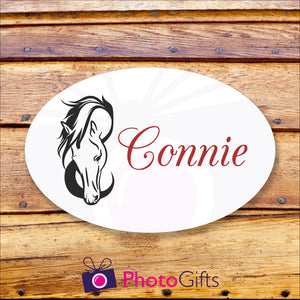 Oval metal outdoor sign on a wooden background. Within the oval panel is a picture of a horses head and to the right is the word "Connie" in red text. All as produced by Photogifts.co.uk